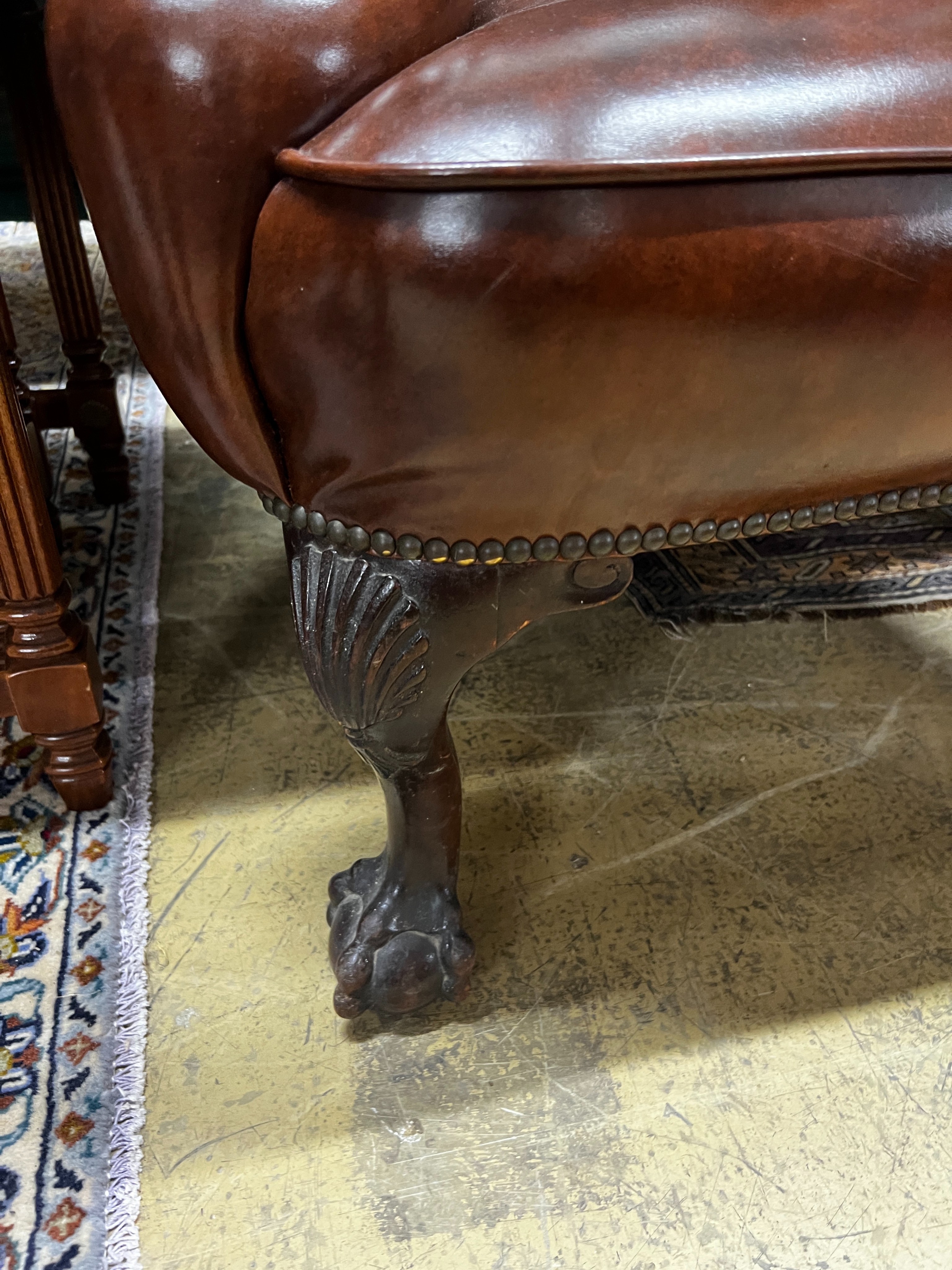 A George II style studded brown leather wing armchair, width 84cm, depth 86cm, height 108cm